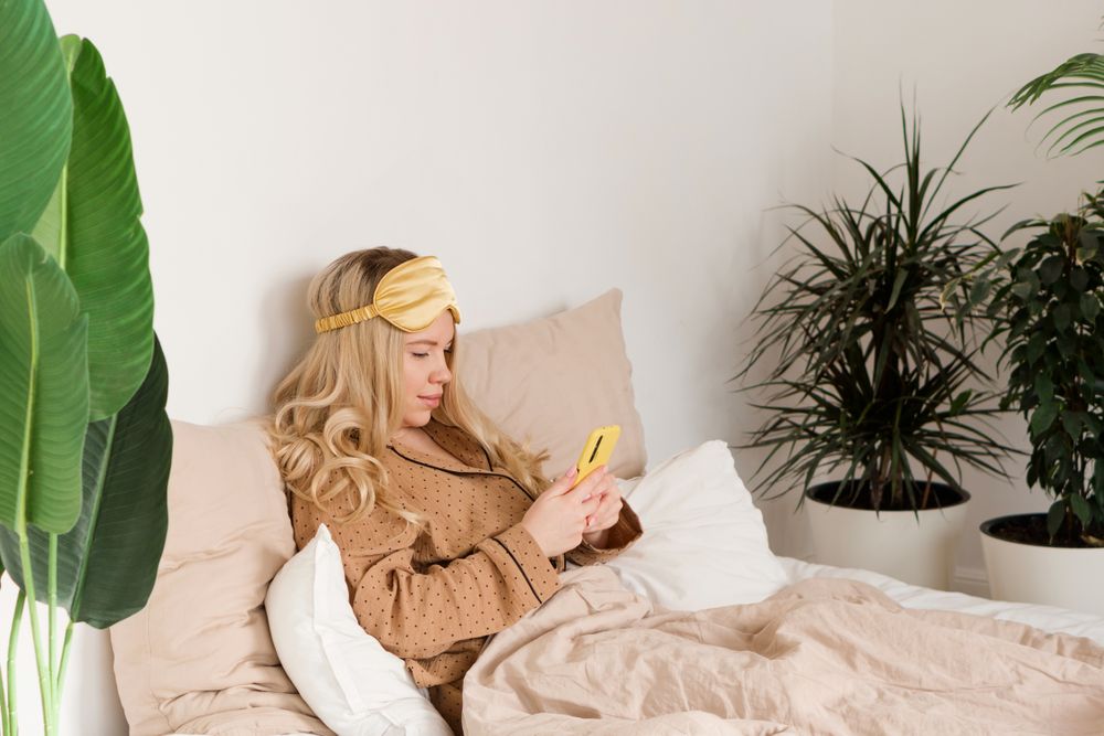 Engrossed in smartphone in morning bed
