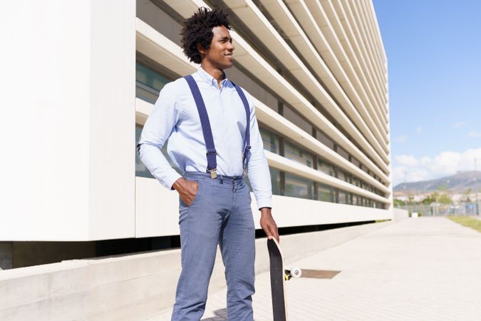 Calm man outside his office with skateboard