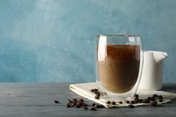 Composition with glass of ice coffee on wooden background