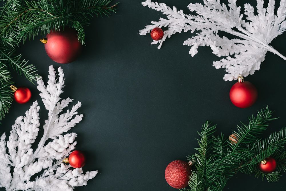 Christmas tree branches with red decorations on dark table background