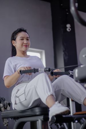 Young woman working out on seated cable row machine at the fitne