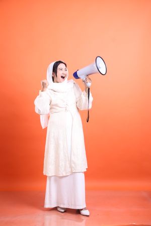 Empowered Voice, Young woman in hijab using megaphone to amplify