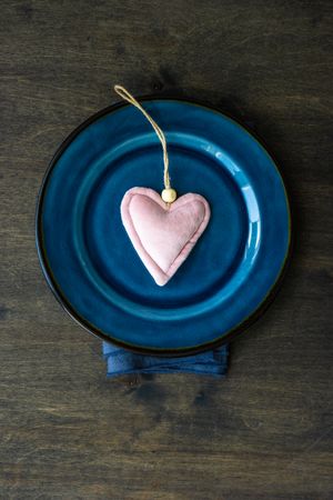 Empty navy bowl on wooden background with heart ornament