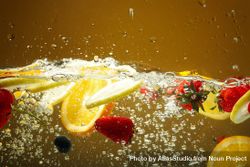 Side view of citrus slices and strawberries suspended in water 42m6y5