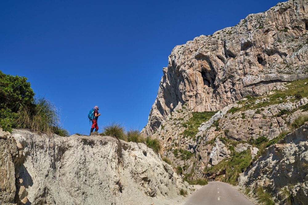 Unrecognizable man with backpack standing in mountains