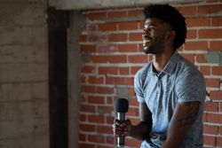 Man sitting and smiling with a microphone