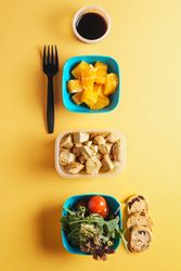 Plastic containers with healthy food and fork