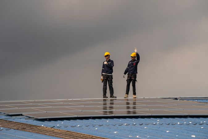 Engineer team checking solar cell  or photovoltaic cell installed on the roof of the factory. Technician worker repair or inspect the system. Industrial renewable energy concept