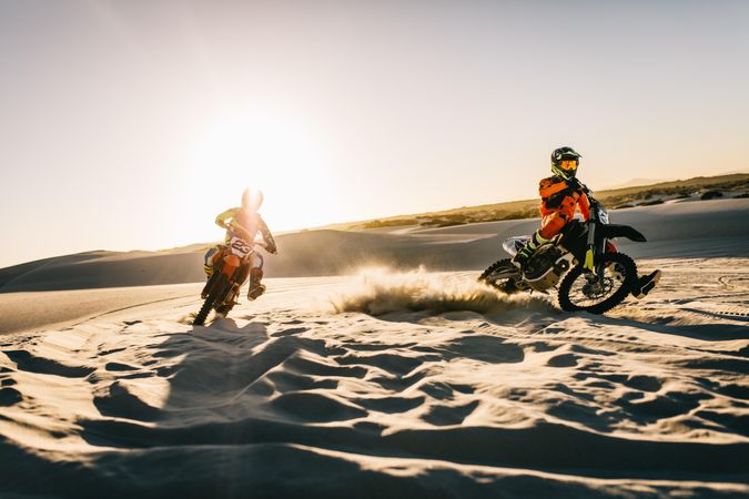 Two motocross racers racing on the off-road terrain