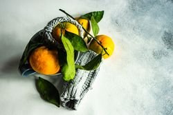 Top view of organic tangerines in cup with woolen cosy