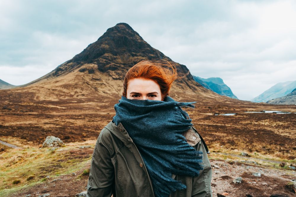 Redhead woman in scarf against mountains