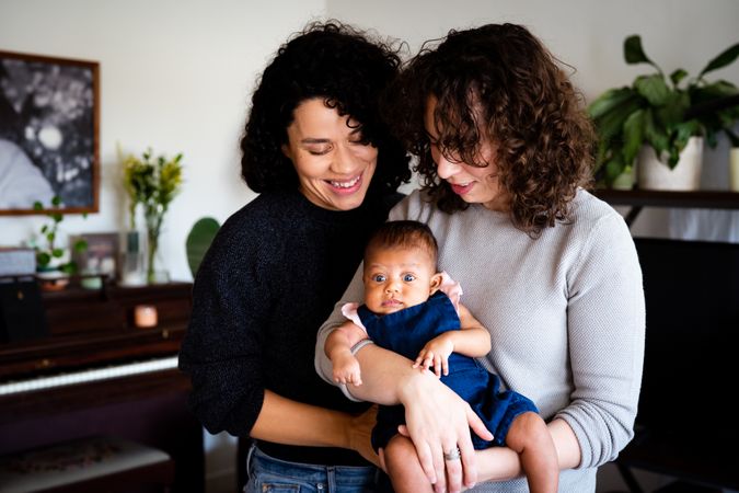 Loving couple looking down at their baby in the living room