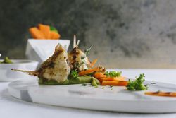 grilled scorpion fish with mashed peas and carrot sticks, on a marble plate