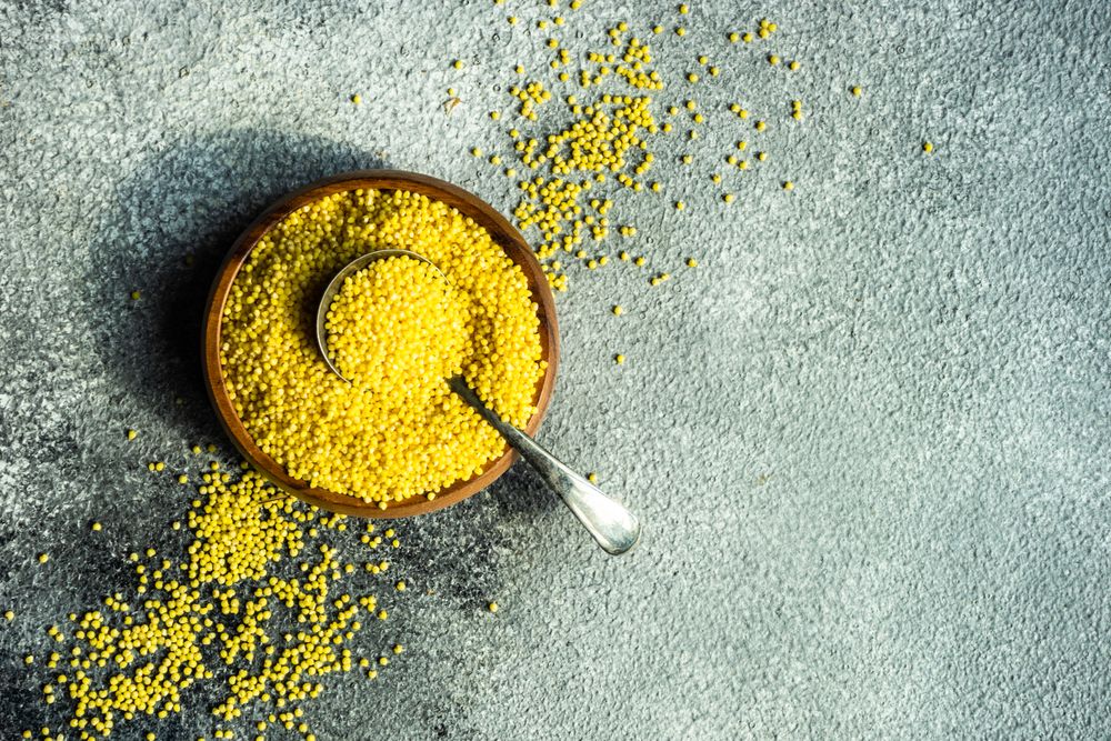 Top view of bowl of dry millet with copy space