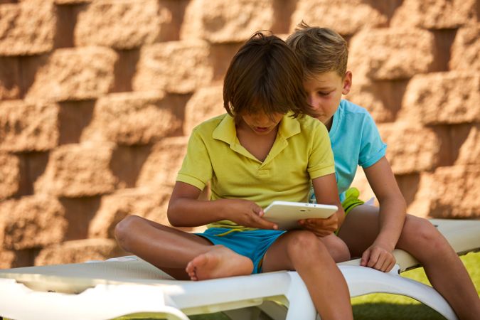 Boys using tablet in garden