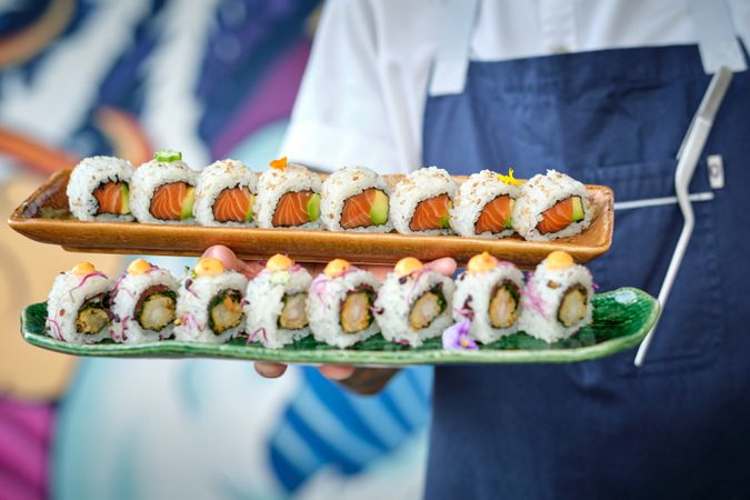 Chef holding trays with delicious sushi rolls