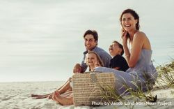 Family sitting on the beach having fun 4mxG75