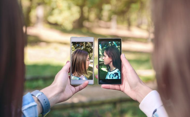 Women showing smartphone screens with side view portraits photos