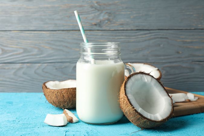 Coconut and milk on blue background, close up