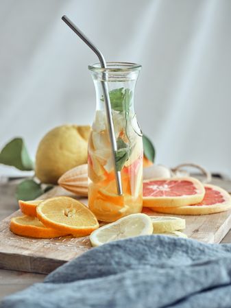 Sliced citruses and lemonade on cutting board