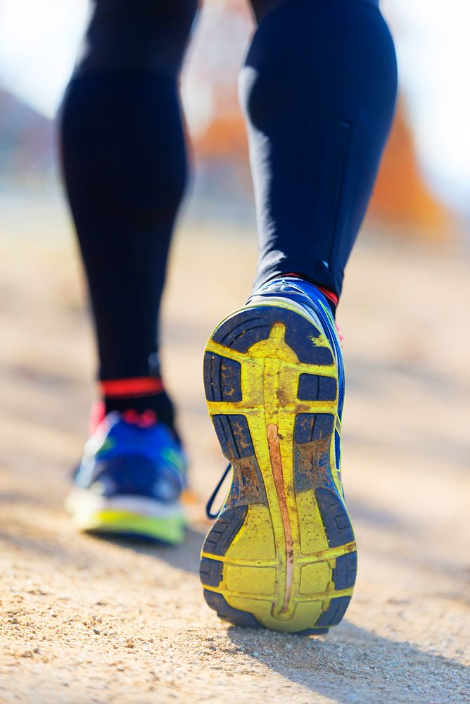 Yellow soles of trainers of person running