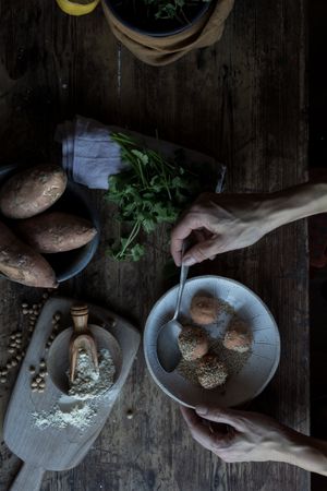 Person rolling in breadcrumbs sweet potatoes