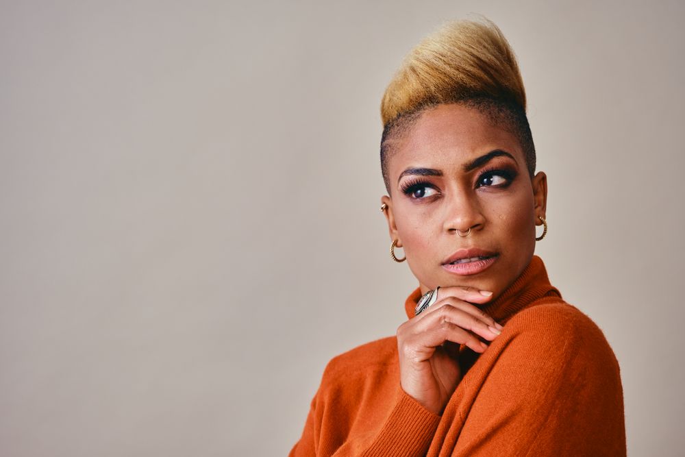 Studio shot of contemplative Black woman with short blonde hair
