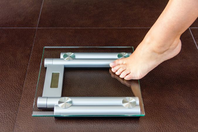 Closeup of woman foot uploading to bathroom scale