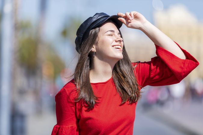 Carefree woman in red shirt smiling into the sun