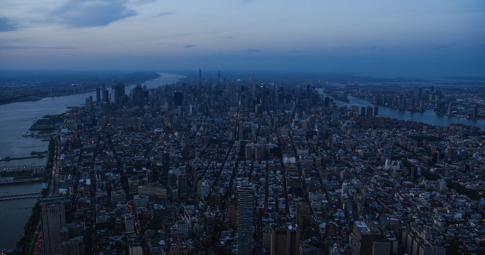 New York City Aerial Evening Cityscape with Stunning Manhattan Landmarks, Skyscrapers and Residential Buildings. Long Wide Angle Panoramic Helicopter View of a Popular Travel Destination