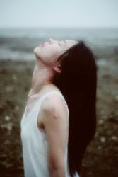 Side view of woman in light tank top leaning her head back