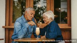 Beautiful portrait of a man and woman sitting at cafe table talking with cold coffee on table 4Ap3W5