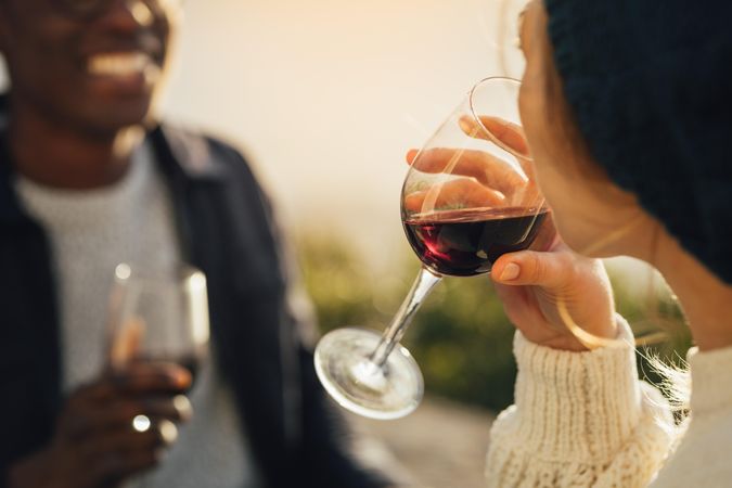 Couple having picnic with focus on wine glass in hand of female