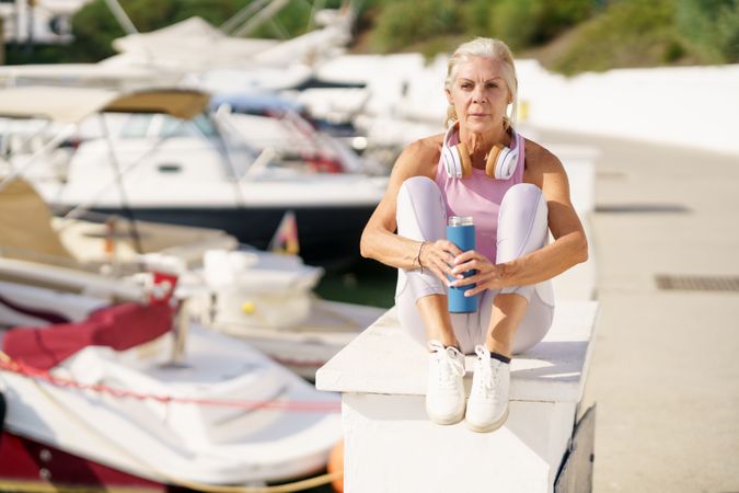 Mature female in sports clothing drinking water from a metal water bottle