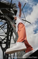 Stylish young man stepping off industrial structure bGKXYb