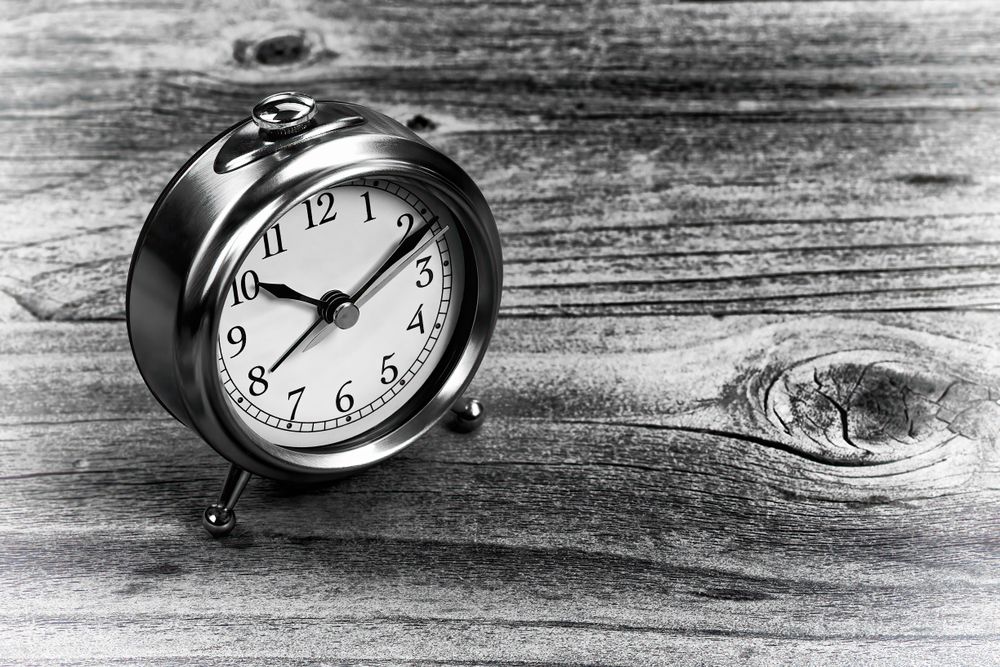 Retro clock on aged wood desk table