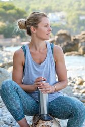 Female dreaming on stony coast after fitness session