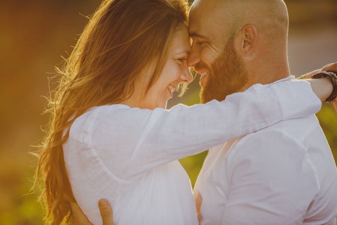 Romantic couple embraced while standing at rural field