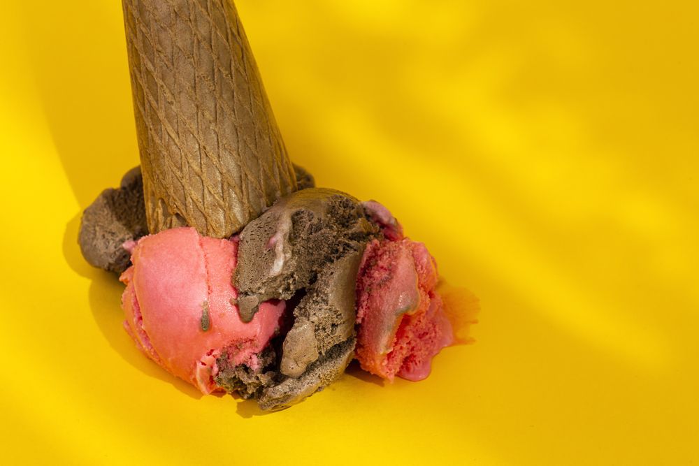 Ice cream cone dropped on yellow background