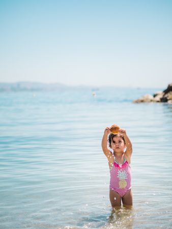 Cute girl playing in water of seaside