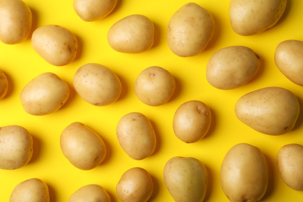 Looking down at potatoes arranged on yellow background