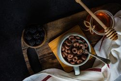Top view of breakfast with chocolate cereal in mug with spoon
