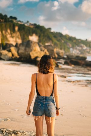 Back of woman on beach at golden hour