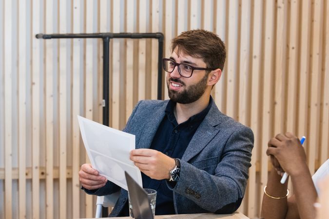 Smiling businessman with document in office