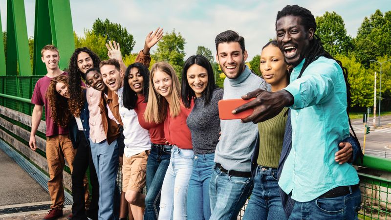 Joyful multiethnic friends taking selfie