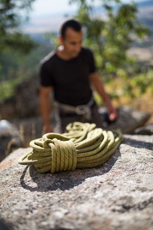 A climber is preparing his ropes to start climbing