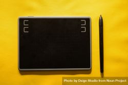 Digital tablet and stylus on yellow background 5kRVrG