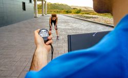 Coach timing woman as she works out
