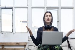 Woman sitting on sofa and relaxing in front of laptop