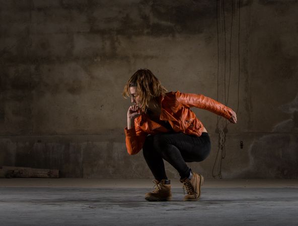 Young woman jumping in grey room